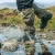Zielone stuptuty Highlander Walking Gaiters podczas przechodzenia przez kamienisty strumień