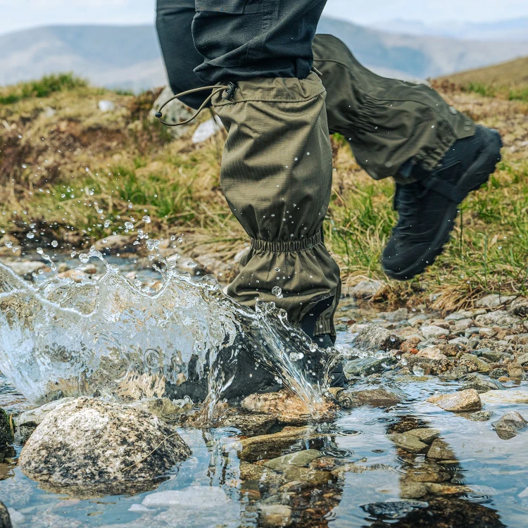 Zielone stuptuty Highlander Walking Gaiters podczas przechodzenia przez kamienisty strumień