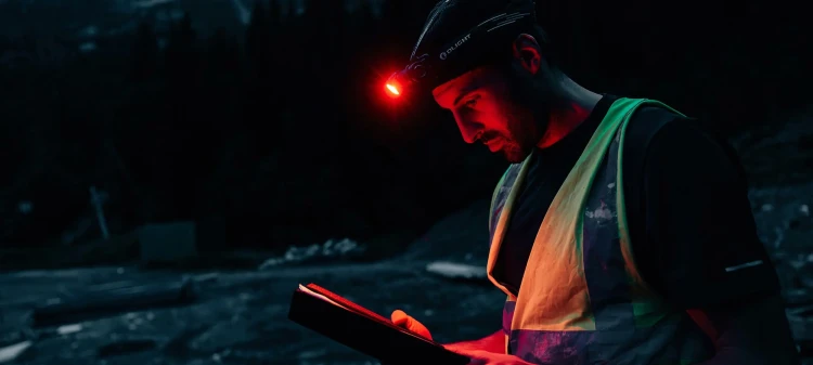 Czerwone światło czołówki Olight Perun 3 Black podczas czytania po zmroku