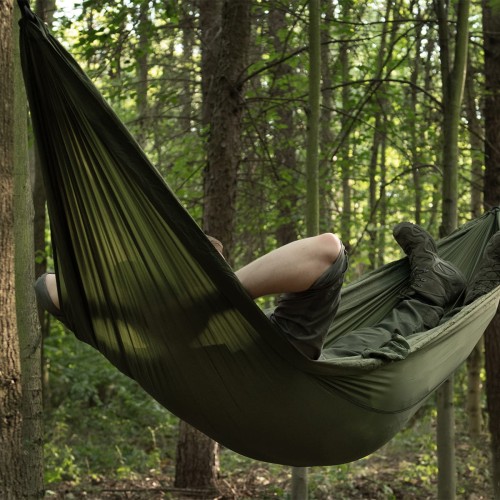 Hamak Badger Outdoor Forest Olive rozwieszony w lesie podczas biwaku