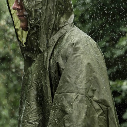 Ponczo Badger Outdoor Olive chroniące przed deszczem podczas wyprawy w lesie