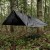 Ponczo Badger Outdoor Black rozpięte jako tarp chroniący przed deszczem w lesie