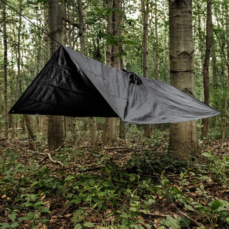 Ponczo Badger Outdoor Black rozpięte jako tarp chroniący przed deszczem w lesie