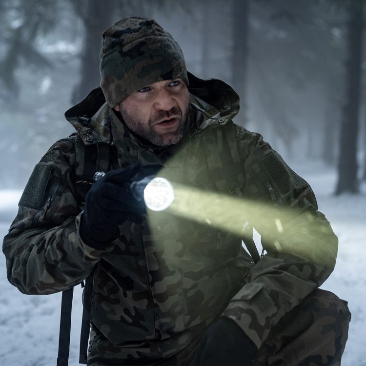 Skupiona wiązka latarki Olight Javelot Turbo podczas działań terenowych