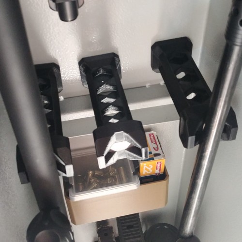 Uchwyty RifleHolder zamontowane w metalowej szafie na broń