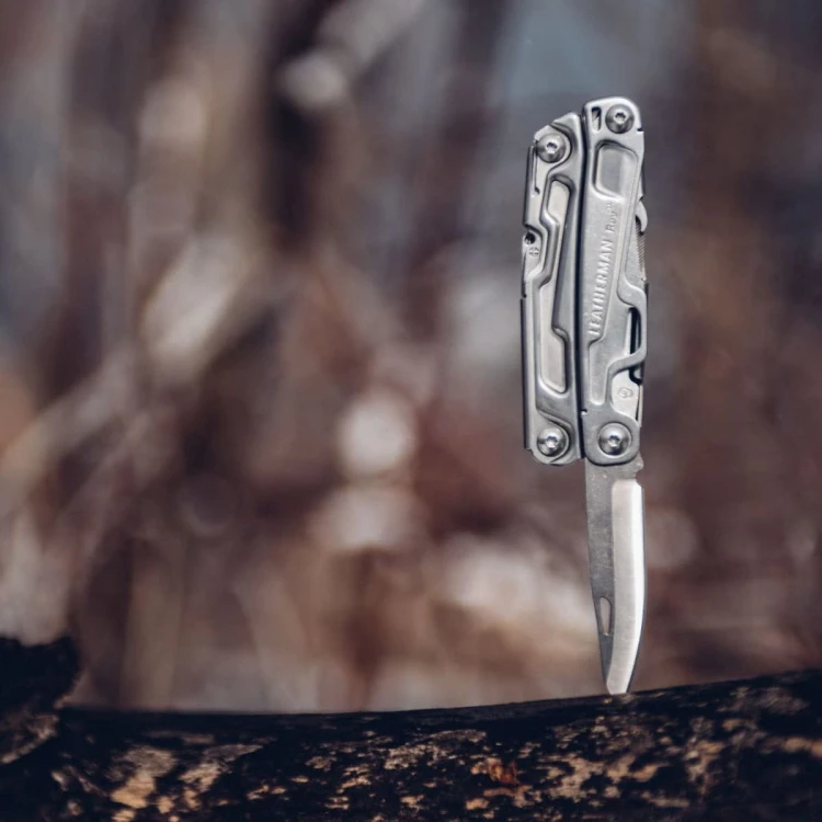 Stalowy multitool Leatherman Rev z ostrzem i rozłożonymi narzędziami
