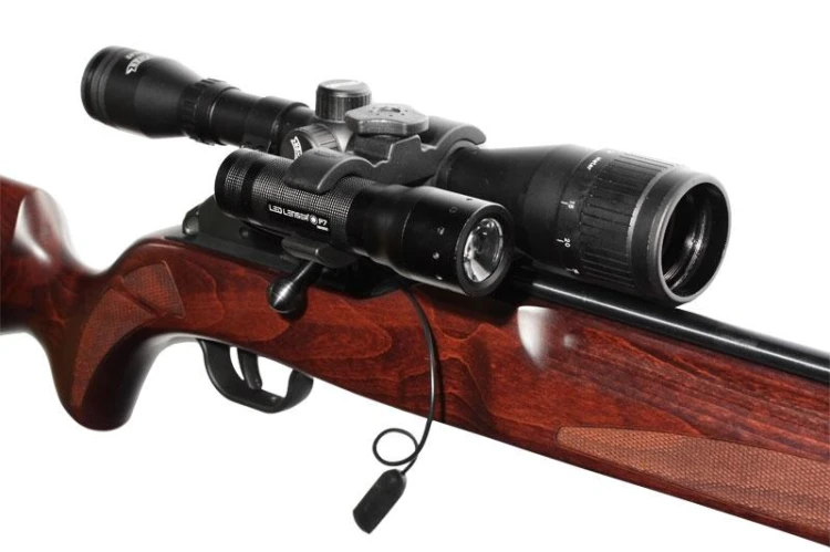 Mocowanie Ledlenser 0362 z latarką zamontowaną na lunecie broni myśliwskiej