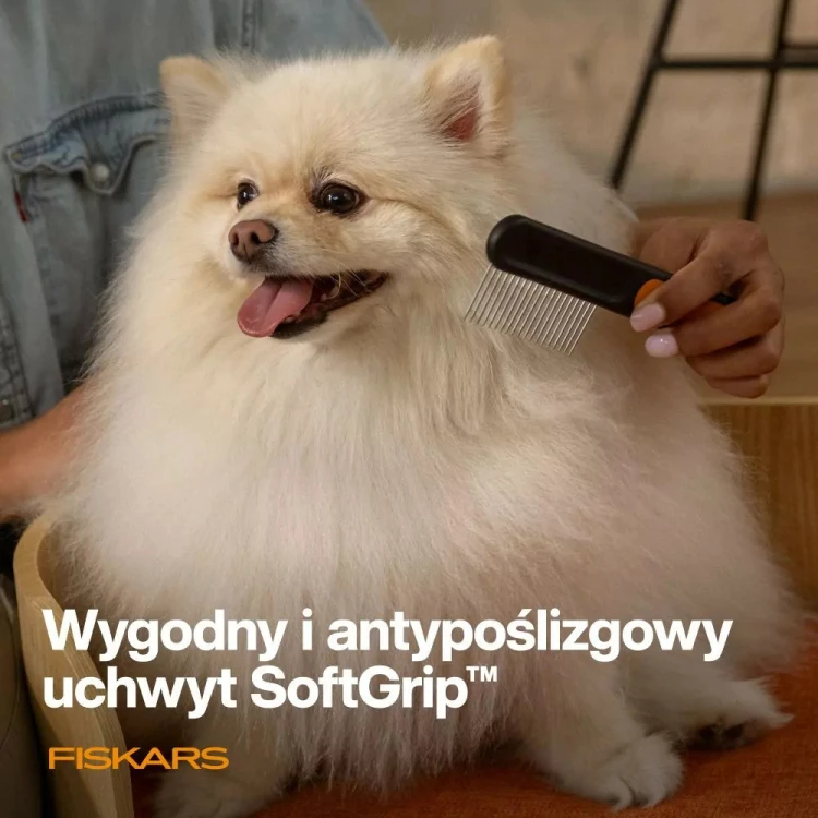 Grzebień Fiskars PET CARE z uchwytem SoftGrip podczas pielęgnacji długiej sierści psa